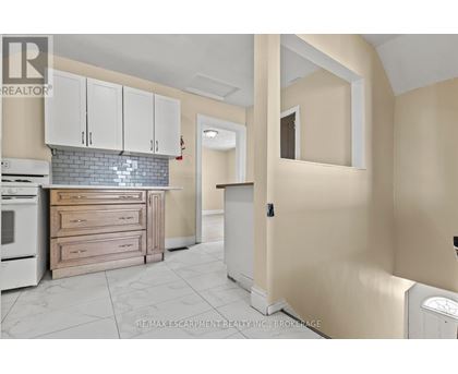 A kitchen with white cabinets and a tiled backsplash.