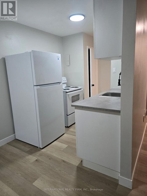 A white refrigerator and a white countertop in a kitchen.
