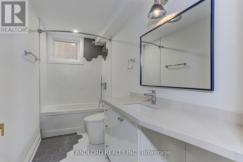 A white bathroom with a toilet, sink, and bathtub.