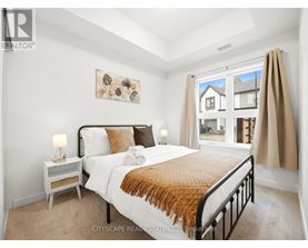 A bedroom with a large bed and a window overlooking a house.