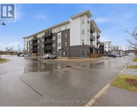 A wet street in front of a multi-story apartment building.