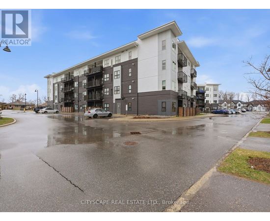 A wet street in front of a multi-story apartment building.