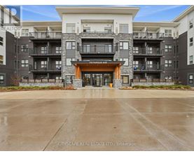 The image shows a multi-story residential building with a large entrance and balconies.