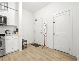 A small, white kitchen with a microwave and oven.