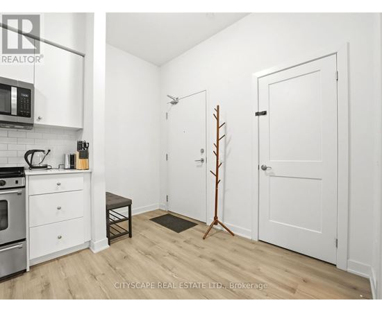 A small, white kitchen with a microwave and oven.