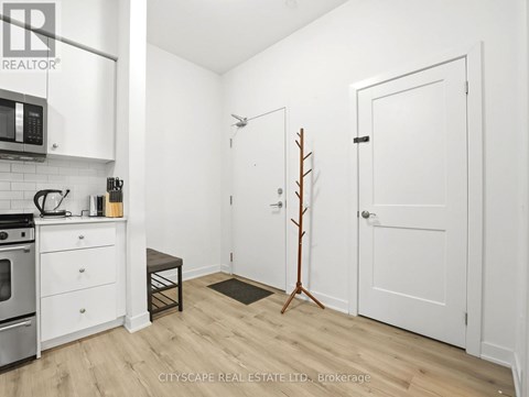 A small, white kitchen with a microwave and oven.