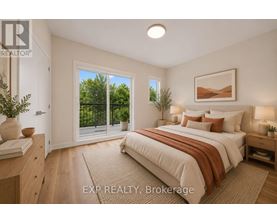 A bedroom with a large bed and a view of trees through the window.