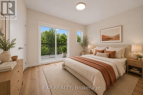 A bedroom with a large bed and a view of trees through the window.
