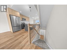 A kitchen with a refrigerator, microwave, and oven.