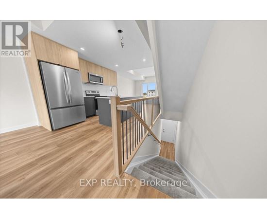 A kitchen with a refrigerator, microwave, and oven.