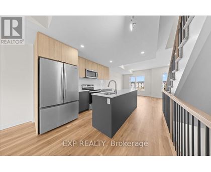 A modern kitchen with wooden cabinets and a stainless steel refrigerator.