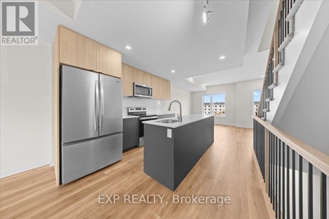 A modern kitchen with wooden cabinets and a stainless steel refrigerator.