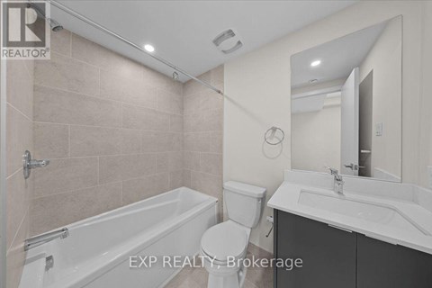A bathroom with a tub, toilet, and sink.