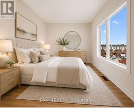 A bedroom with a large bed, a nightstand with a lamp, and a framed picture on the wall.