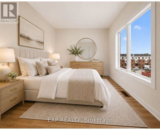 A bedroom with a large bed, a nightstand with a lamp, and a framed picture on the wall.
