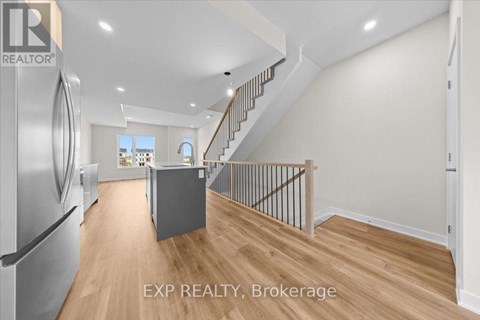 A kitchen with a refrigerator and a staircase.