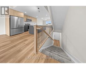 A kitchen with a refrigerator, stove, and microwave.