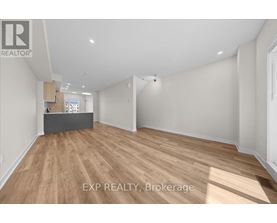 A room with wooden flooring and white walls, with a desk in the corner.