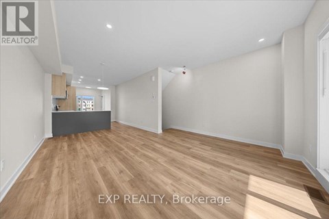 A room with wooden flooring and white walls, with a desk in the corner.