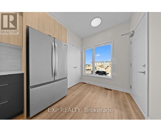 A kitchen with a refrigerator and a window showing a view of a building.