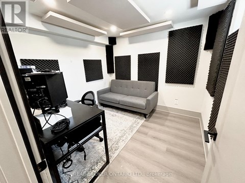 A room with a desk, a couch, and a TV.