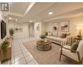 A living room with a couch, chair, and potted plants.