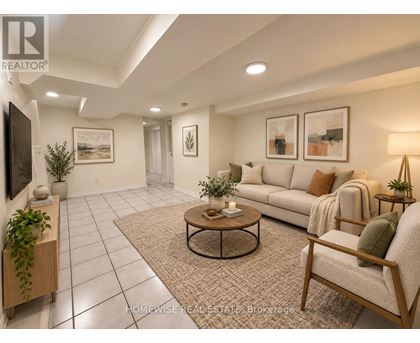 A living room with a couch, chair, and potted plants.