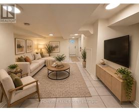 A living room with a white sofa, a wooden chair, a coffee table, and a flat-screen TV.