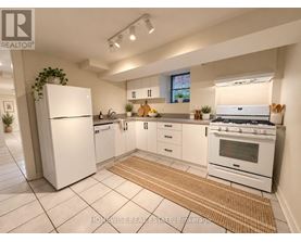 A white kitchen with a refrigerator, oven, and sink.