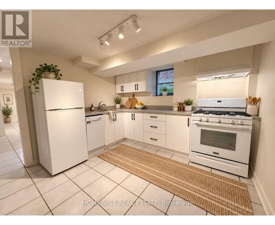 A white kitchen with a refrigerator, oven, and sink.