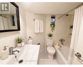 A white bathroom with a sink, toilet, and bathtub.
