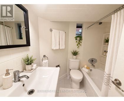 A white bathroom with a sink, toilet, and bathtub.