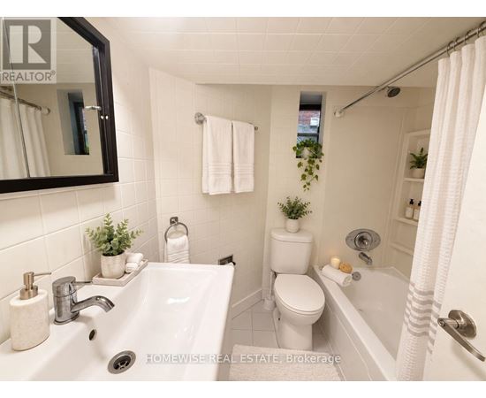 A white bathroom with a sink, toilet, and bathtub.