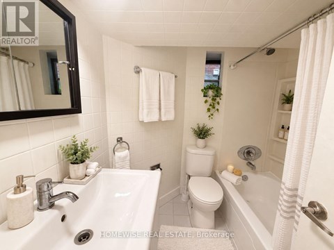 A white bathroom with a sink, toilet, and bathtub.
