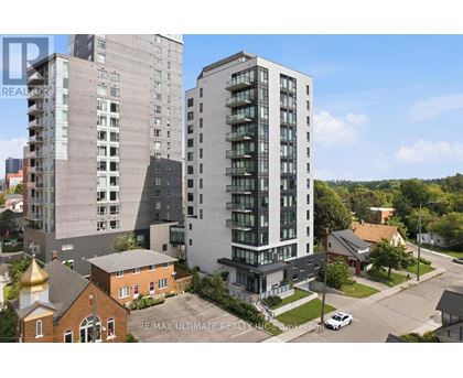 A modern apartment building is in the foreground with a church and other buildings in the background.