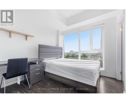 A bedroom with a bed, chair, and window.