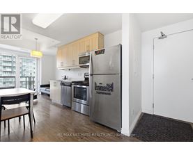 A kitchen with a refrigerator that has a calendar magnets on it.