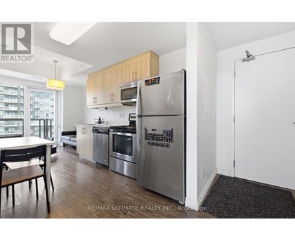 A kitchen with a refrigerator that has a calendar magnets on it.