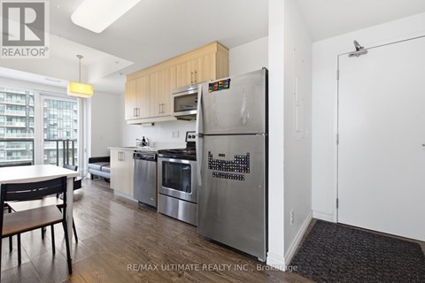 A kitchen with a refrigerator that has a calendar magnets on it.