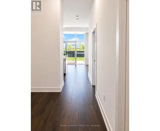 A long hallway with white walls and wood floors.