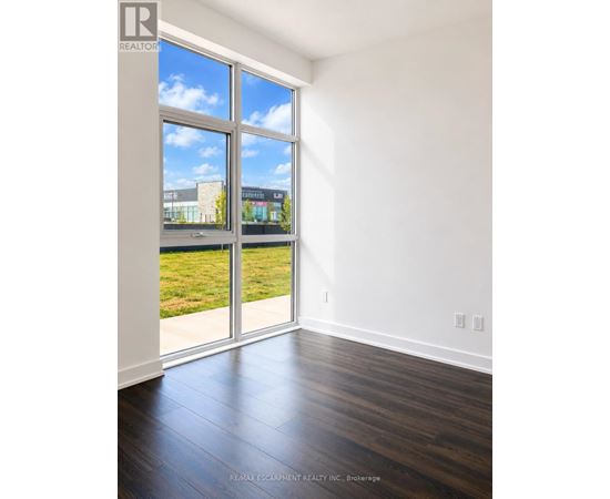 A room with a large window and sliding glass doors.