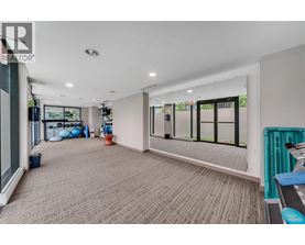 A spacious room with a carpeted floor and large windows.