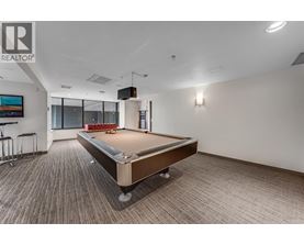 A pool table in a room with a Realtor logo on the wall.