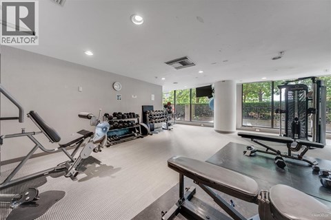 A gym with a variety of equipment including treadmills, weights, and exercise machines.
