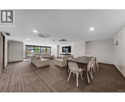A living room with a brown carpet and white furniture.