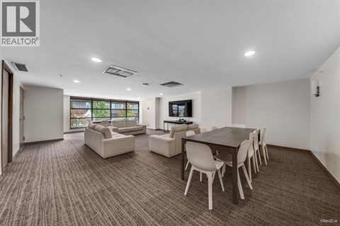 A living room with a brown carpet and white furniture.