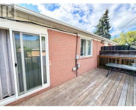 A red brick house with a wooden deck and a glass door.