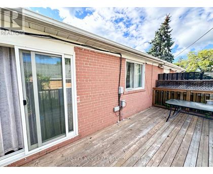 A red brick house with a wooden deck and a glass door.