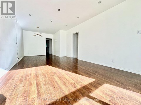 A room with wooden flooring and a ceiling fan.