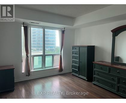 A room with a large window and wooden floors.
